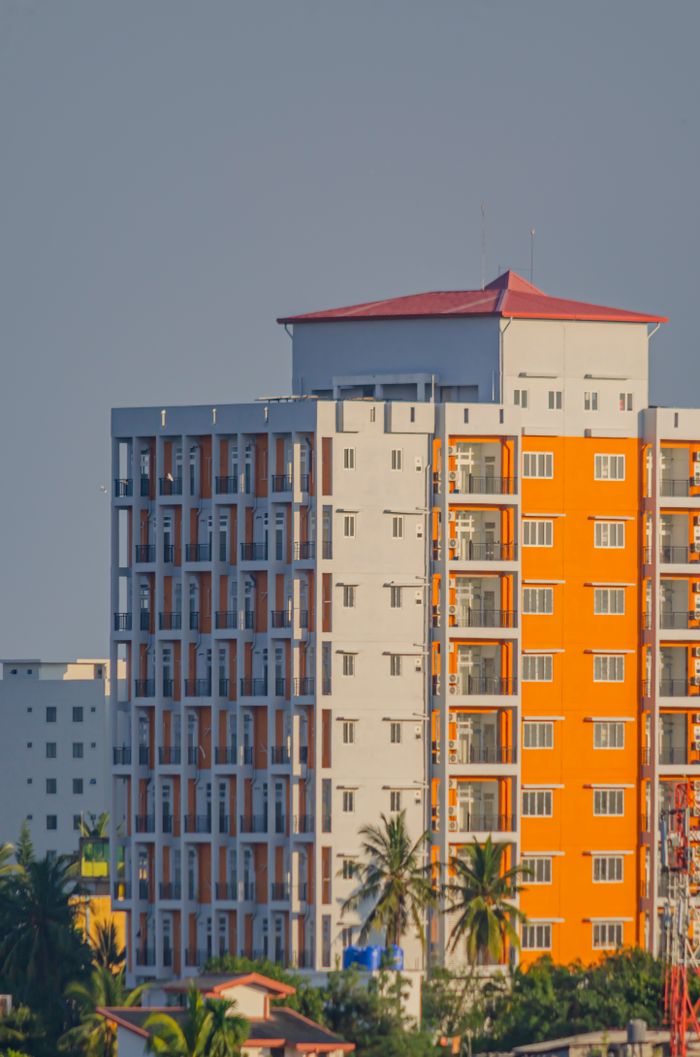 Brightly colored modern apartment building in Sri Lanka with palm trees.